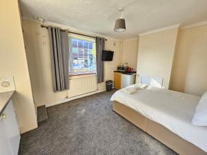 a bedroom with a bed and a window at Central Studios 87 Tennyson Road in Cheltenham