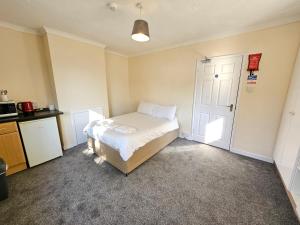 a small bedroom with a bed and a door at Central Studios 87 Tennyson Road in Cheltenham