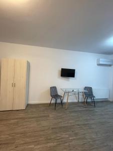a room with two chairs and a table and a tv at Best View luxury in Costinesti
