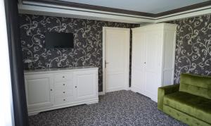 a living room with a couch and a tv on a wall at Casa del Monte - Dorna Arini in Dorna Arini