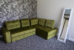 a green couch in a room with a mirror at Casa del Monte - Dorna Arini in Dorna Arini
