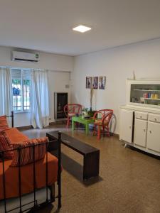 Una sala de estar con un sofá y sillas y una mesa. en Casa Anne, en Tandil