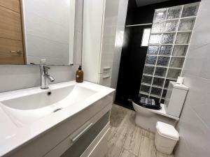 a white bathroom with a sink and a toilet at La Casita Gergaleña, Confort in Gérgal +30 photos