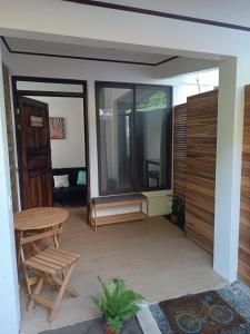a screened in patio with a table and chairs at Aracari Garden Hostel in Tortuguero