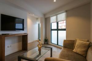 a living room with a couch and a tv at 1BR near Central Restaurant in Barranco by Wynwood House in Lima