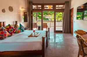 a bedroom with a bed with a table and chairs at The Lodge at Jaguar Reef in Hopkins +67 photos