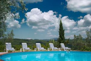 un gruppo di sedie sedute accanto a una piscina di Hotel Girifalco - Nature & Relax a Massa Marittima