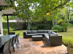 un patio avec un canapé, une table et des chaises dans l'établissement Maison de charme à Savigny-sur-Clairis avec piscine et sauna., à Savigny-sur-Clairis