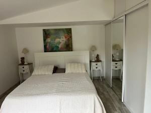 une chambre blanche avec un lit et deux tables de nuit dans l'établissement Maison de charme à Savigny-sur-Clairis avec piscine et sauna., à Savigny-sur-Clairis