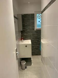 une salle de bain avec un lavabo blanc et une fenêtre dans l'établissement Maison de charme à Savigny-sur-Clairis avec piscine et sauna., à Savigny-sur-Clairis