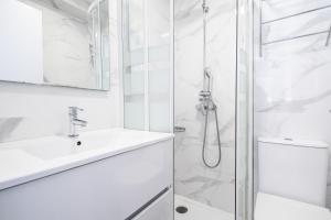 ein weißes Badezimmer mit Dusche und Waschbecken in der Unterkunft Penthouse El Pato 872 Levante Beach in Benidorm