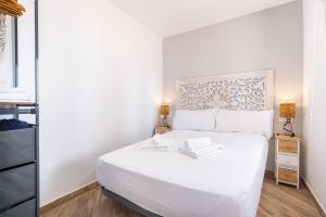 ein Schlafzimmer mit einem großen weißen Bett mit zwei Lampen in der Unterkunft Penthouse El Pato 872 Levante Beach in Benidorm