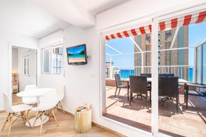 ein Wohnzimmer mit einem Balkon mit einem Tisch und Stühlen in der Unterkunft Penthouse El Pato 872 Levante Beach in Benidorm