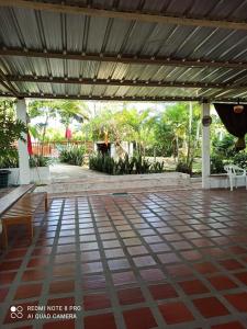 an outdoor patio with benches and awning and a table at Casa de campo in Caguán