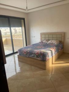 a bedroom with a bed and a large window at Sablet mohammedia in Pont Blondin