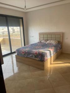 a bedroom with a bed and a large window at Sablet mohammedia in Pont Blondin