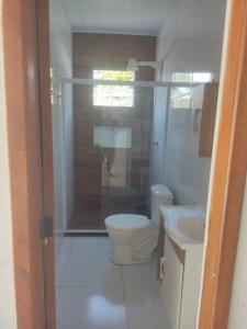 a bathroom with a shower and a toilet and a sink at Casa com piscina in Camacari