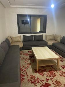 a living room with a couch and a coffee table at Sablet mohammedia in Pont Blondin