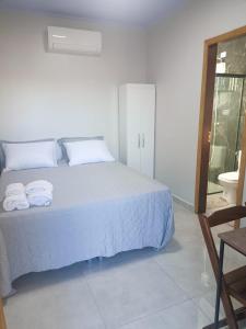 a bedroom with a white bed with towels on it at La Bella Luna Suítes in Alto Paraíso de Goiás