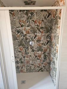 a bathroom with a wall with a floral wallpaper at La Dolce Vita Apartments Amalfi in Salerno +11 photos