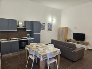 a kitchen and living room with a table and a couch at La Dolce Vita Apartments Amalfi in Salerno