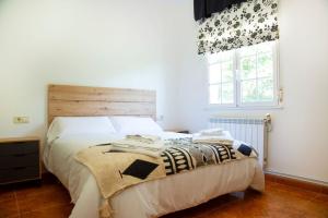 a bedroom with a bed with a wooden headboard and a window at Welcome A Casiña de Arcos de Furcos in Cuntis +13 photos