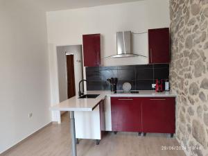 a kitchen with red cabinets and a white counter top at La Porte Verte in Capendu +15 photos