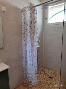 a shower with a shower curtain in a bathroom at La Porte Verte in Capendu