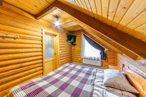 a bedroom with a bed in a wooden cabin at Затишні котеджі SVI in Bukovel
