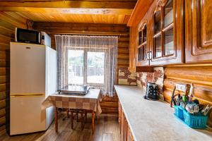 a kitchen with a refrigerator and a table in a room at Затишні котеджі SVI in Bukovel