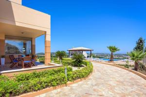 Cette maison dispose d'une terrasse avec une table et un kiosque. dans l'établissement Aegean Blue Villa, à Koskinou