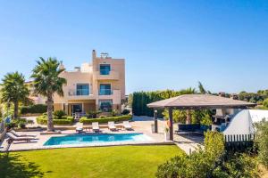 a villa with a swimming pool and a house at Aegean Blue Villa in Koskinou
