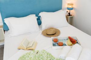 a tray of fruit and a book on a bed at Helen Beach Front Luxury Villas in Kastraki Naxou +60 photos