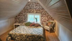 a attic bedroom with a bed and a window at Villa Kämparo in Enhörna
