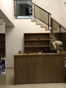 a man sitting at a counter with a staircase at Pousada Royal in Mossoró