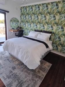 a bedroom with a large white bed with a wall at Troon Harmony - Room 3 in Durban +9 photos
