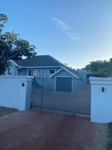 a fence with two gates in front of a house at Troon Harmony - Room 3 in Durban