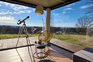 a camera on a tripod next to a table with a telescope at Kućica za odmor Srbac in Srbac