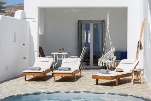 a room with chairs and a swimming pool at Helen Beach Front Luxury Villas in Kastraki Naxou