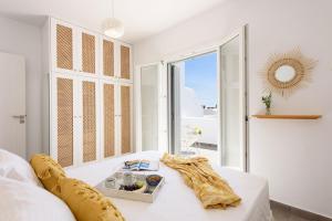 a white room with a table with a tray of food at Helen Beach Front Luxury Villas in Kastraki Naxou