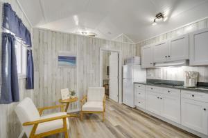 Una cocina con gabinetes blancos y una mesa y sillas. en Pet-Friendly Picayune Tiny Home about 4 Mi to Downtown, en Picayune