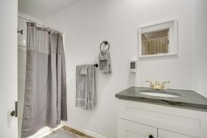 Un baño blanco con lavabo y ducha. en Pet-Friendly Picayune Tiny Home about 4 Mi to Downtown, en Picayune