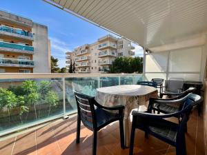 Una mesa y sillas en un balcón con vista a un edificio. en Cala Beach, en Salou