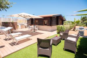 a patio with chairs and a table and an umbrella at Chalet Seaview by AR Group Hotels in Isola delle Femmine