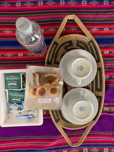 a picnic basket with a tray of donuts and a bottle of water at Cabaña Apacheta Mi Campito Cachi Salta in Cachí +15 photos