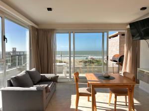 een woonkamer met een bank en een tafel bij Zelena Voda in Villa Gesell