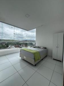 a white bedroom with a bed and a large window at Casa para o Natal perto do palco centro, 3 quarto in Garanhuns +17 photos