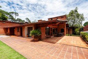 a brick house with a patio in the yard at Incredible Property with Huge Garden and Pool! in Valle de Bravo