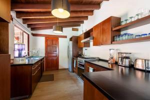 a kitchen with wooden cabinets and a black counter top at Incredible Property with Huge Garden and Pool! in Valle de Bravo