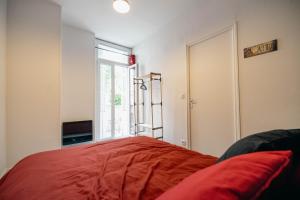 a room with a red pillow and a window at Le séjour ciné-Proche du centre-wifi-parking in Lourdes